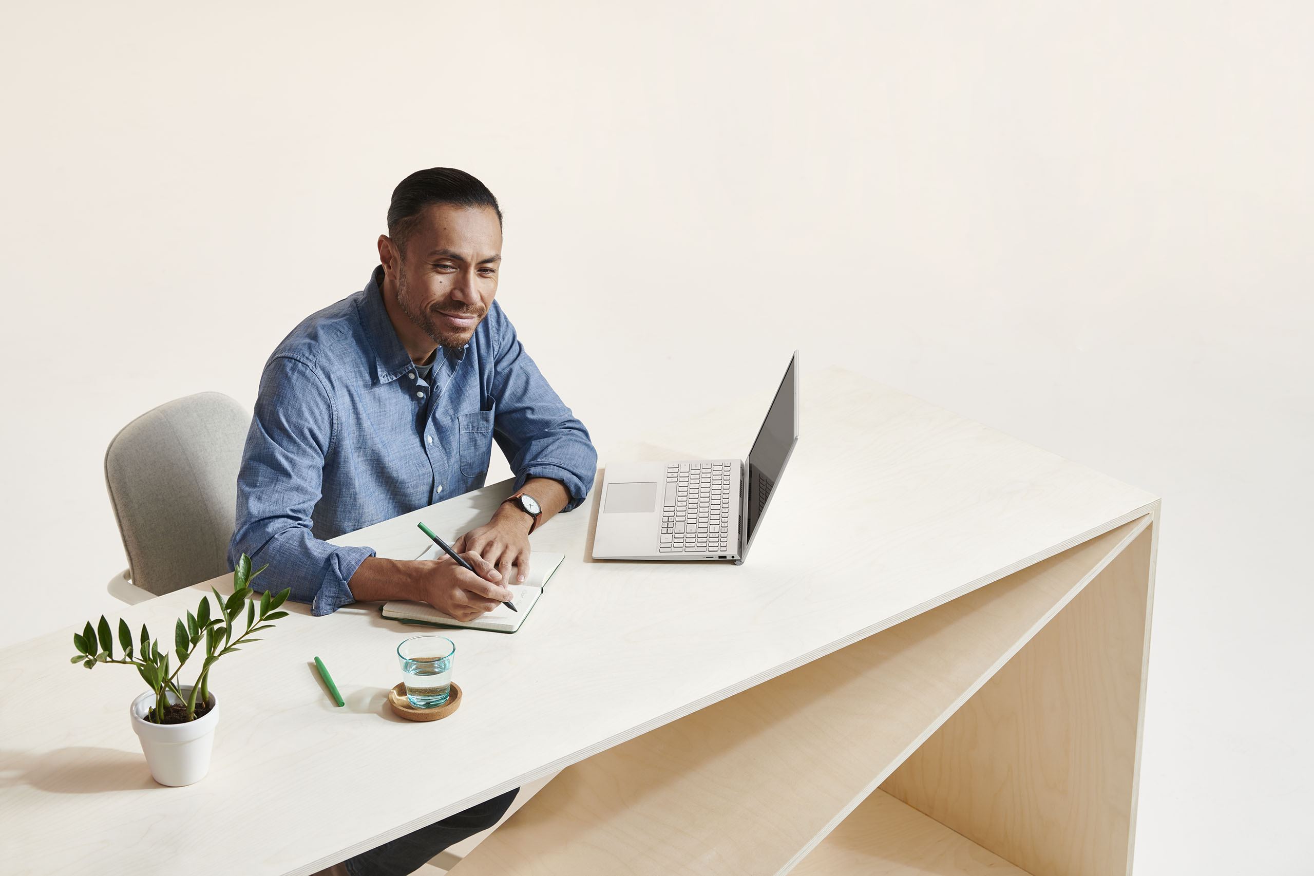 Man at desk writing in notepad